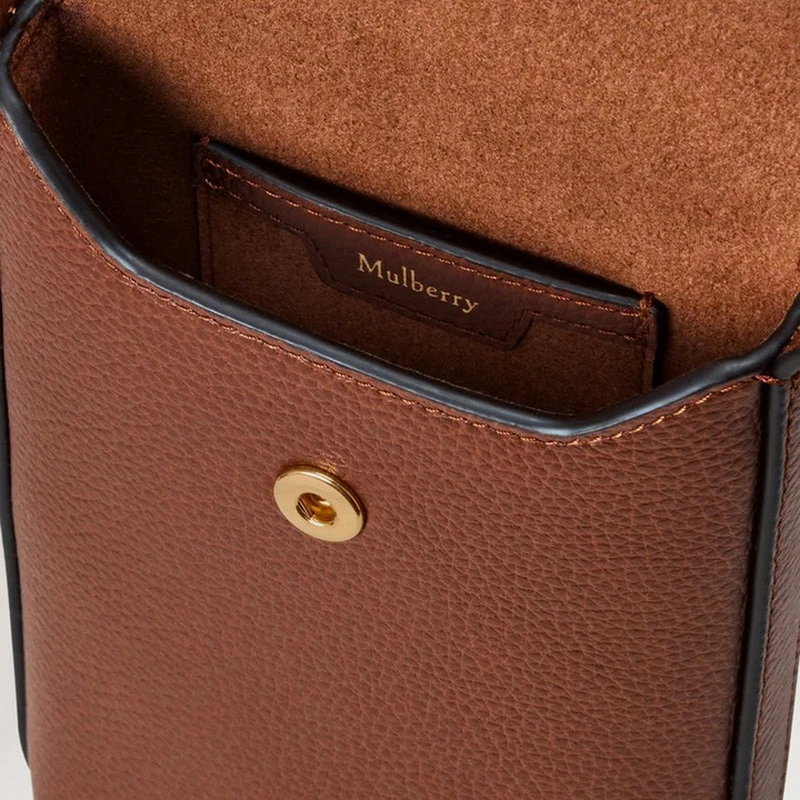 Mulberry Telefoonhoesje met drukknopen, eik met close-up van bruin leren oppervlak en goudkleurige drukknop, model RL9007552G110