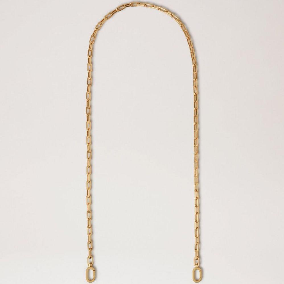 Mulberry Softie Chain Crossbody Strap van glanzend messingkleurig metaal, elegante ketting tegen lichte achtergrond. ModelRX0289000N188