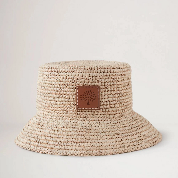 Mulberry Summer Raffia Bucket Hat toont een helder gevlochten raffia zomerhoed met leren detail aan de voorkant. ModelVH4097807H120
