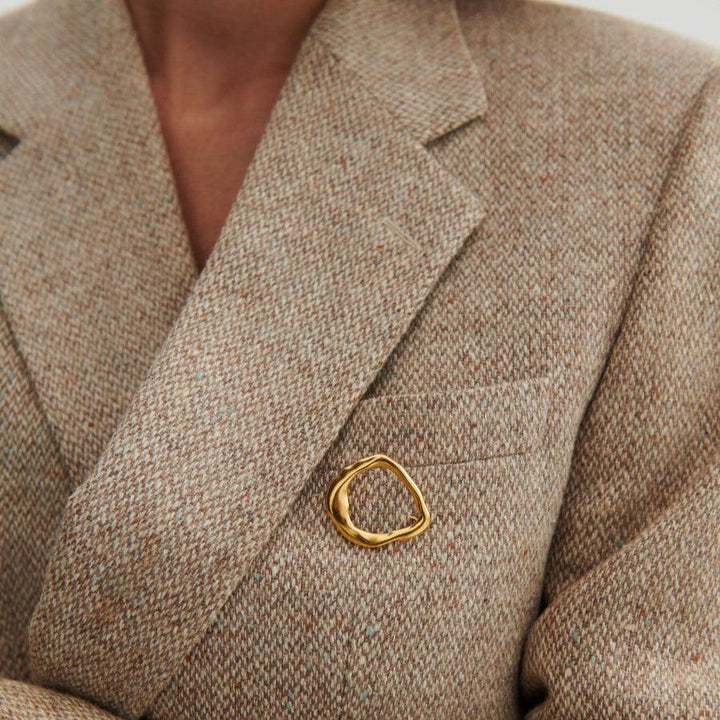 Pernille Corydon Gaia vergulde zilveren broche gezien op een beige jas, organische gouden vorm, model C-001-GP