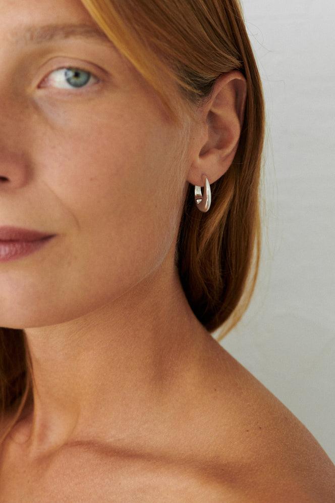 Pernille Corydon Globe Huggies in zilver gedragen door model, eenvoudige en elegante stijl. Model E-401-S