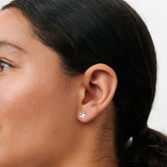 Pernille Corydon Mini Wild Poppy Stud Earrings toont een zilveren bloemvormige oorbel in model. Model E-369-S