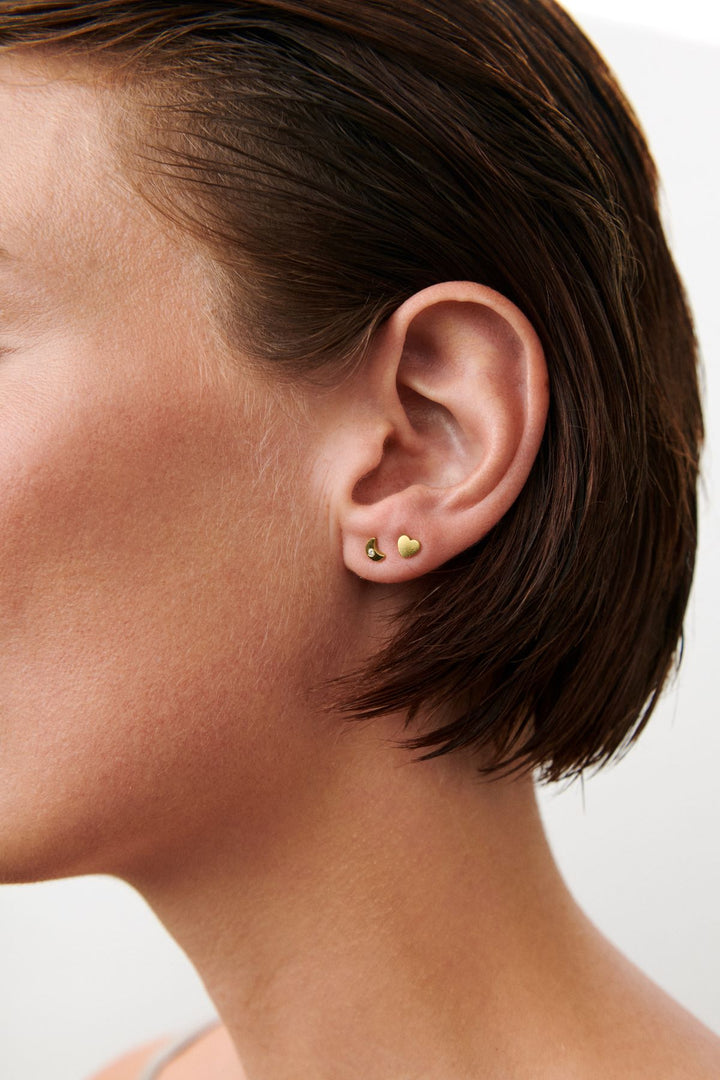 Pernille Corydon Night Light Earsticks worden op het oor getoond, kleine vergulde oorsticks in een minimalistisch design. Model C-122-GP-2