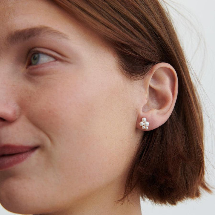 Pernille Corydon Ocean Bay vergulde pareloorbellen dicht bij het oor gedragen, vrouwelijke witte parels. Model E-442-GP-2.