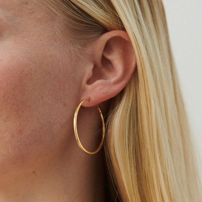 Pernille Corydon Small Orbit Hoops verguld gedragen op het oor, slanke ronde gouden oorbel. Model E-052-GP.
