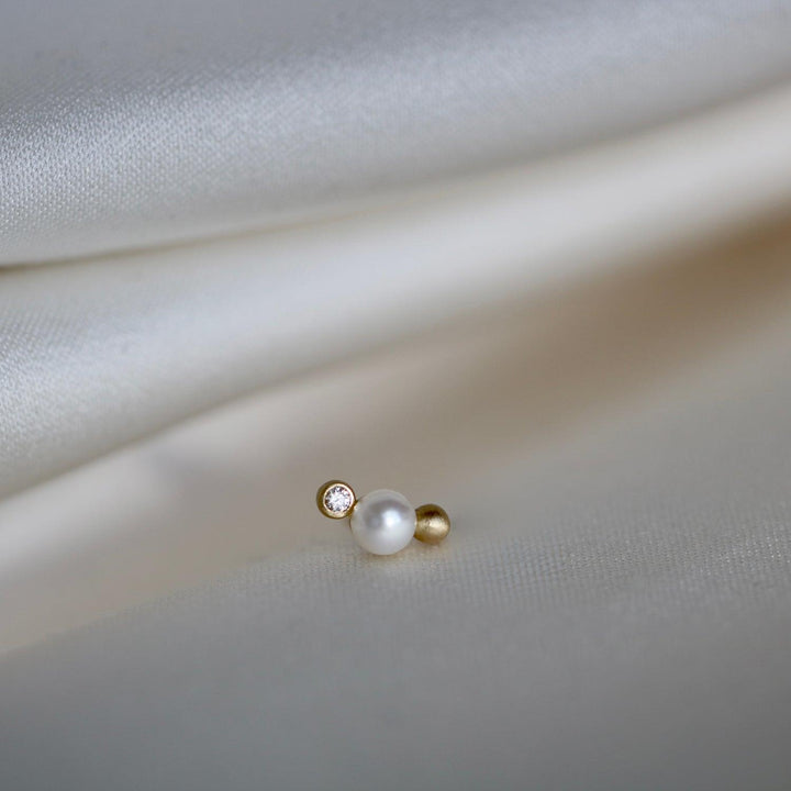 RO Copenhagen Orbit Dot WWF-oorknopjes hebben een enkel parel-, diamant- en gouddetail op heldere stof. ModelE118Y103-2