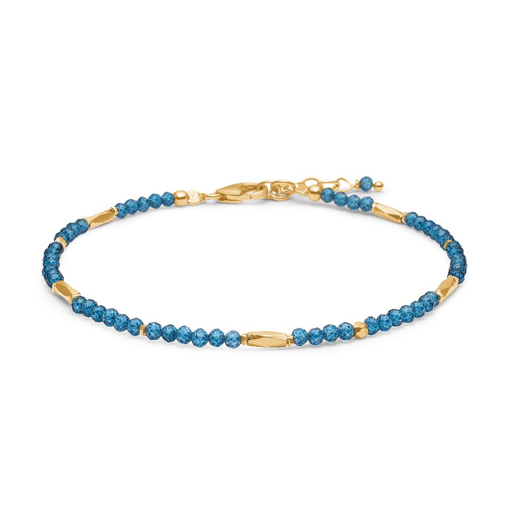 studio-z-evergreen-armband-met-london-blauw-topaas weergegeven als delicate armband met blauwe edelstenen en gouden details. Modelnummer 8256851