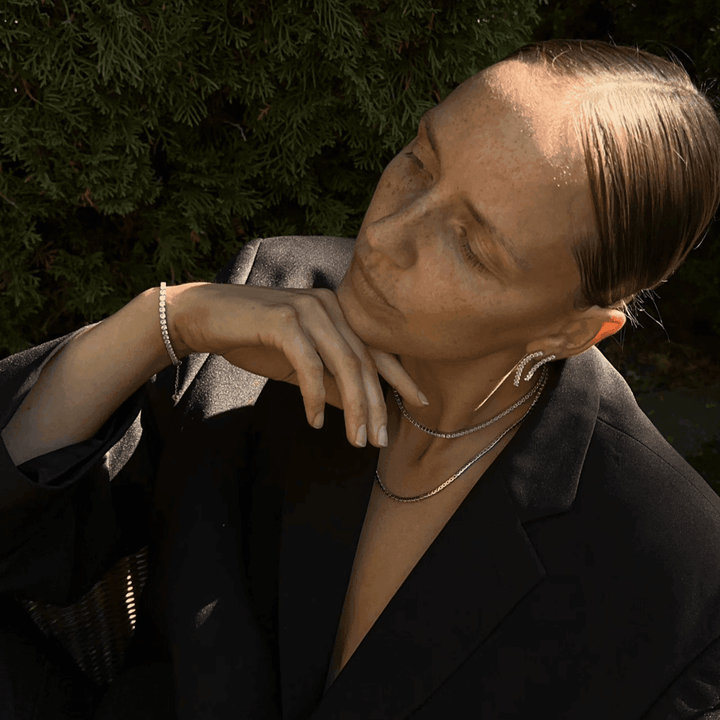 Studio Z Tennisketting in verguld zilver, gedragen door model buitenshuis met zwarte blazer, model 7227000-2.