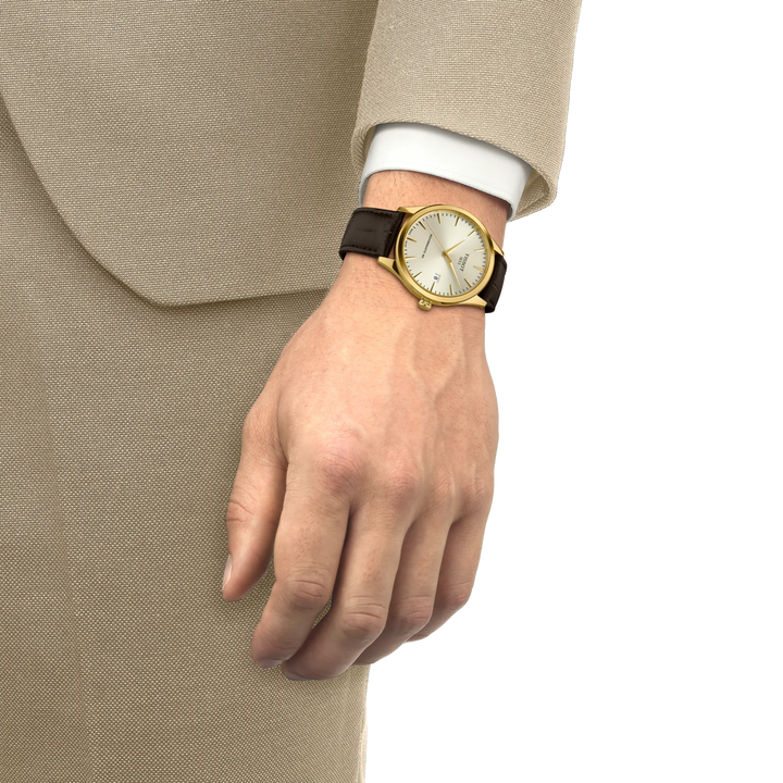 Tissot Classic Dream Powermatic 80 goud PVD met bruin leren band gedragen om de pols, model T1584073626100