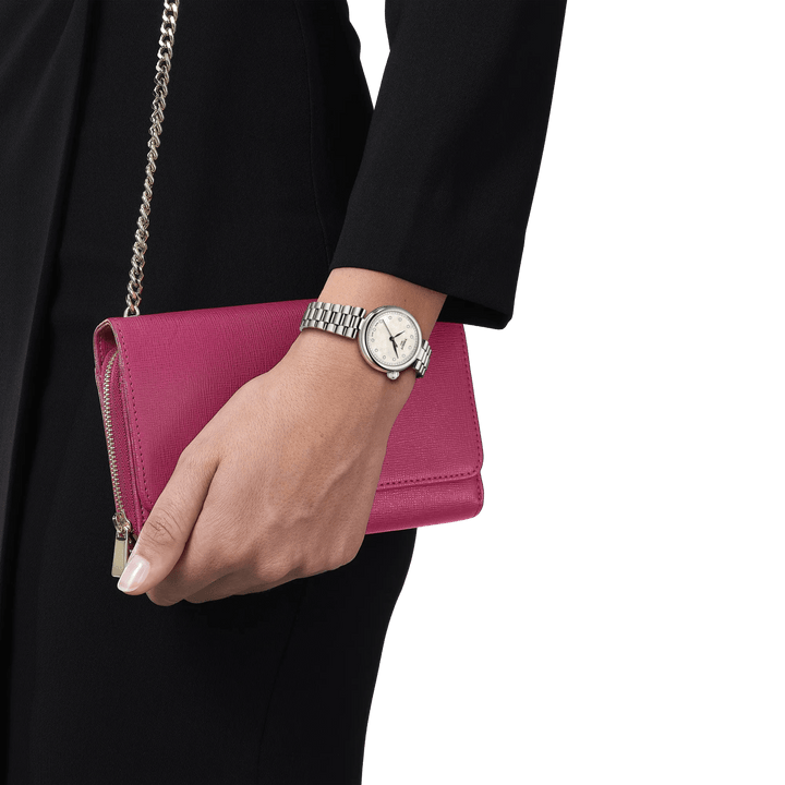 Tissot Desir 28 mm parelmoer wijzerplaat en diamanten weergegeven op de pols, zilveren horlogeband, elegante uitstraling. ModelT1520101111600