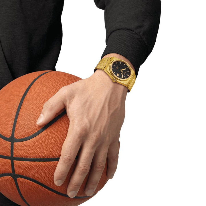 Tissot PRX Powermatic 80 Damian Lillard Special Edition draag bij de hand met basketbal goudkleurig horloge. ModelT1374073305100