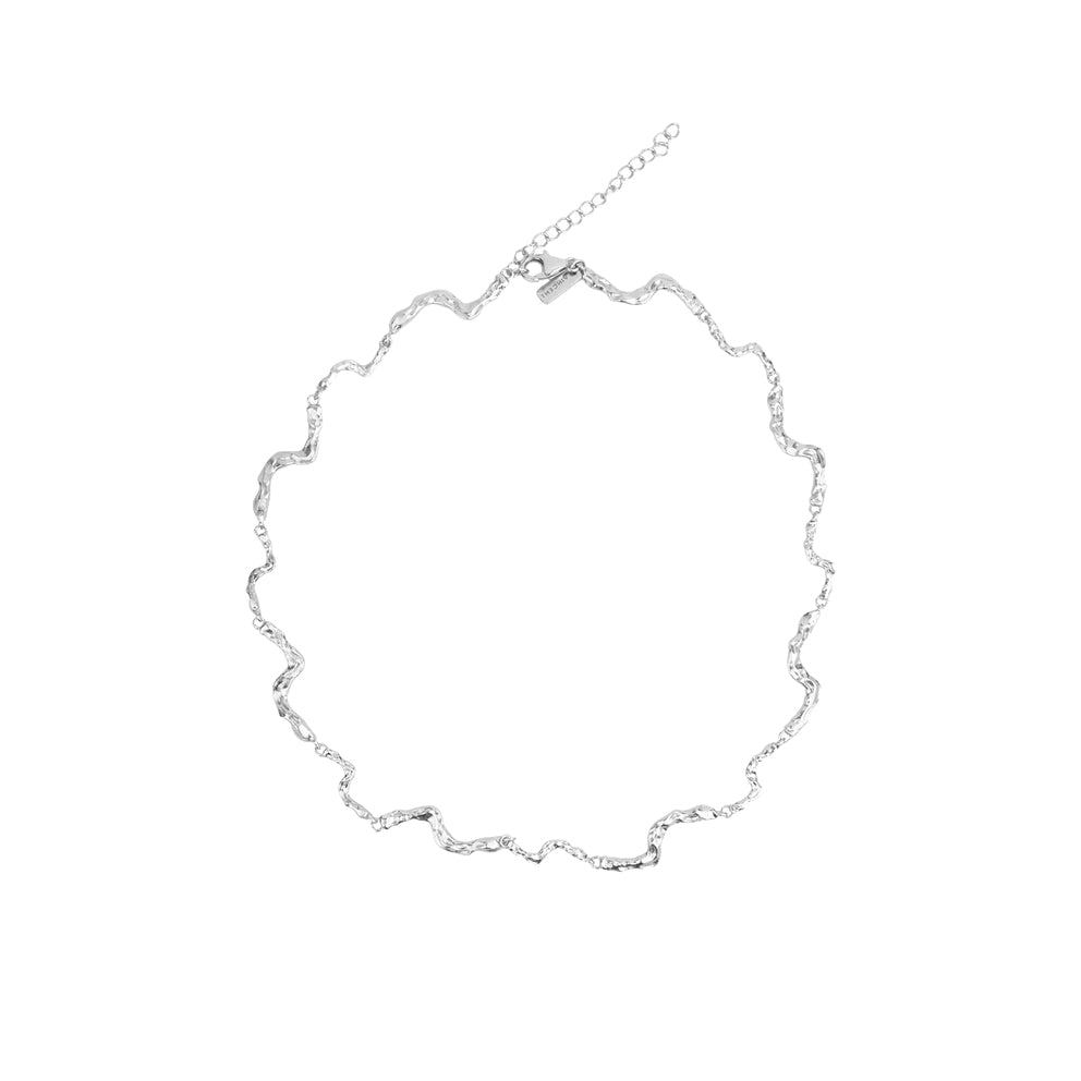 Vincent Nightfall zilveren ketting afgebeeld op witte achtergrond met golvende, glanzende zilveren structuur. ModelVJ127