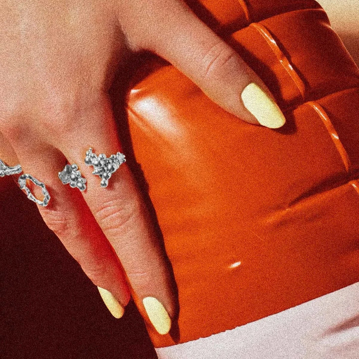 Vincent Orb Chronicles Solv Ring, elegante zilveren ring met organisch ontwerp bij de hand met heldere nagels voor oranje achtergrond. ModelVJ163-URS-001-2