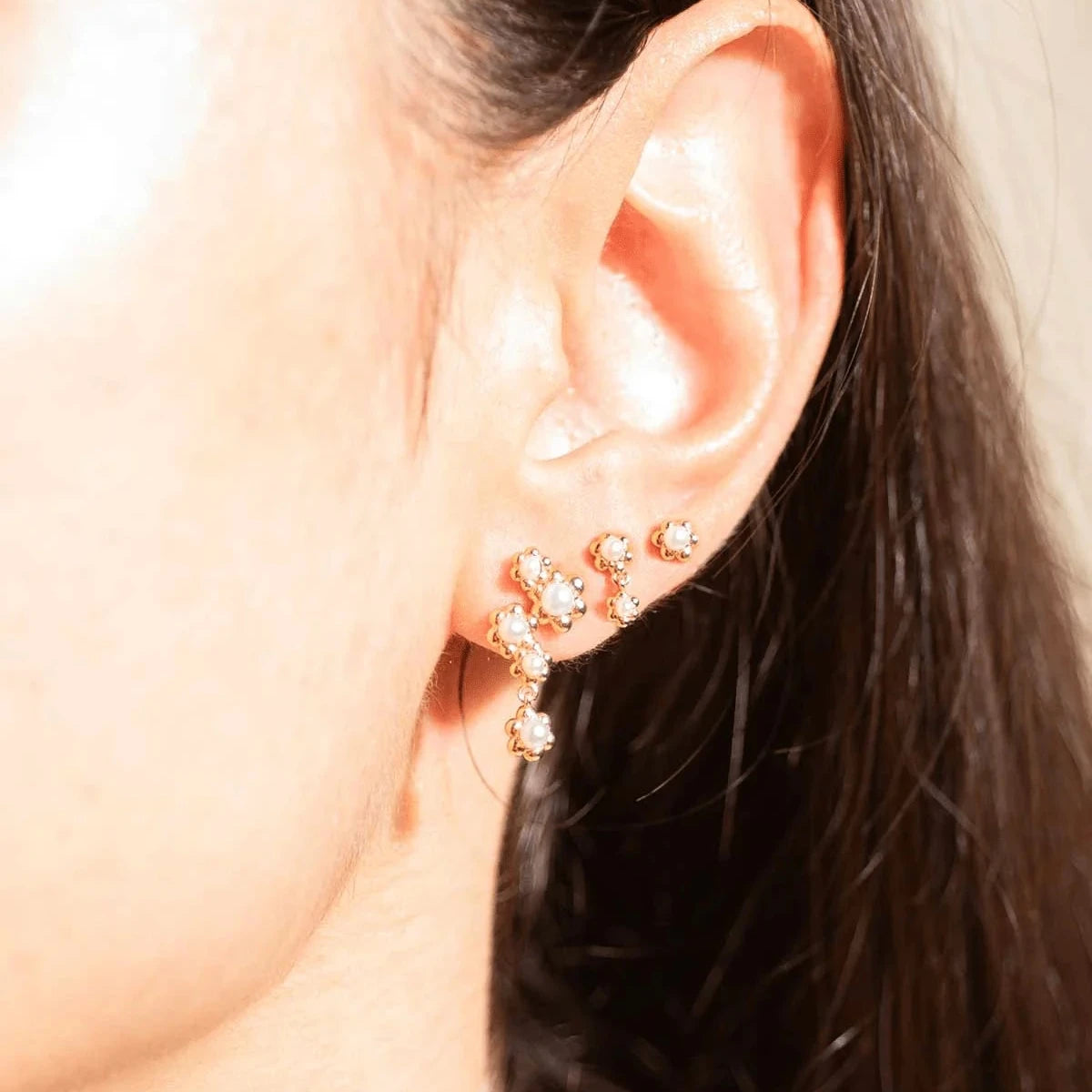 Vincent Venus Bloom Oorbellen Verguld Set van 3 Oorbellen toont drie fijne vergulde oorbellen met witte steentjes op het oor. Model VJ246-UEG