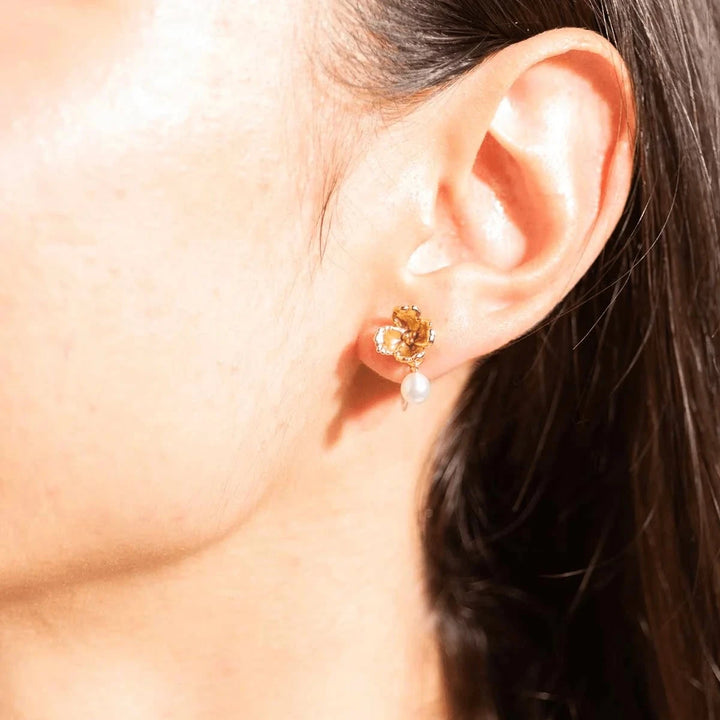 vincent venus fleur brede oorbellen verguld met zoetwaterparel gedragen in het oor, detail met parel en gouden bloem. ModelVJ248-UEG-1