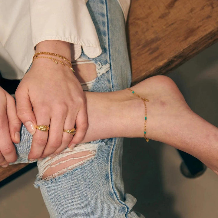 Wioga Octavia enkelketting verguld met turkoois afgebeeld op de enkel, casual stijl. ModelA-8638-GP-1.