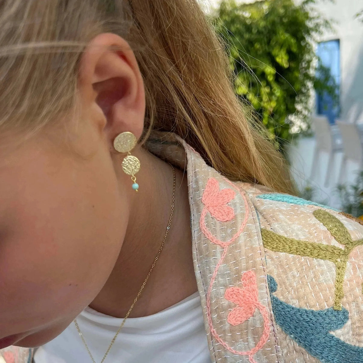 Sisse Marie-oorstekers met gouden plaatjes en blauwe lapisparel worden buiten gedragen getoond, model E-8804-GP.