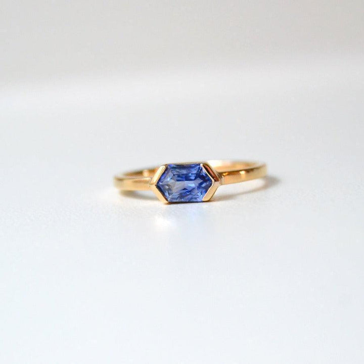 Anpe Atelier Ring op maat met blauwe saffier van dichtbij weergegeven, elegant in goud met zeshoekige blauwe saffiersteen. Model 27-blasafir-001-1