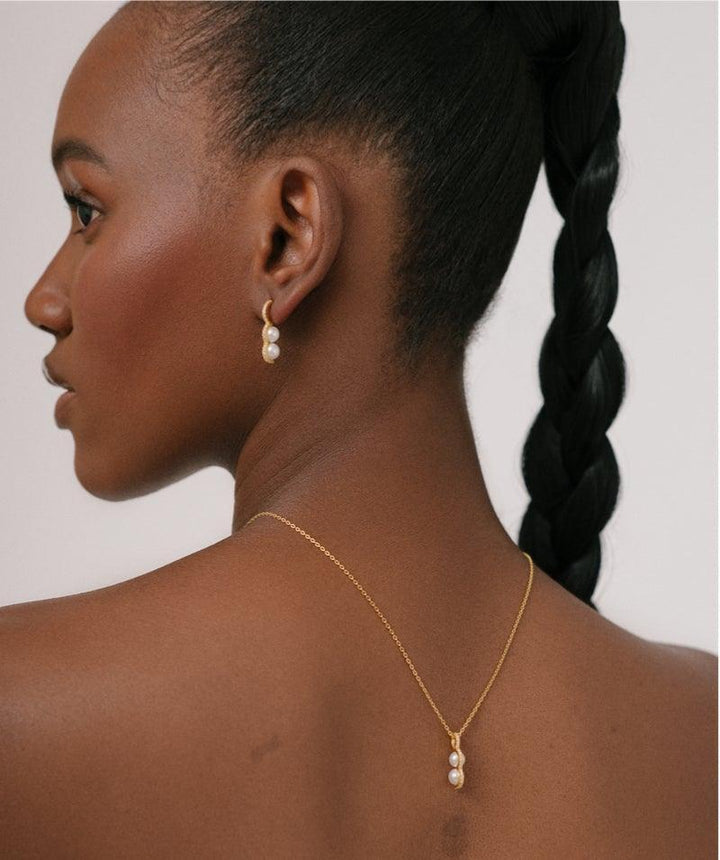 Herieth Paul x Polar Jewelry Bahati ketting gedragen door model, elegant goud met parels. Model BAH-NL-GD-WP-WZ-00503-2