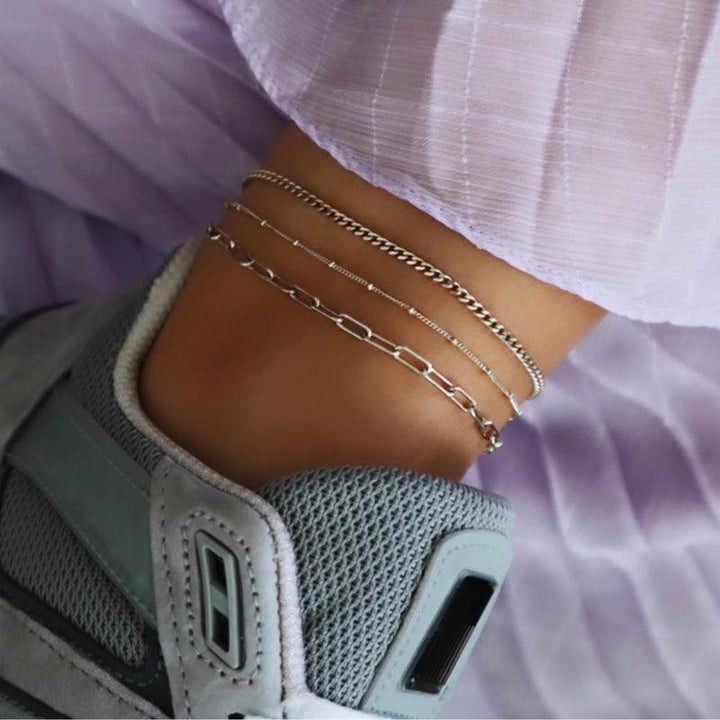 jeberg-jewellery-sophia-solv-anklekaede toont een zilveren enkelbandje op een enkel met een sneaker en lichtpaarse stof. Model 4550-S-2