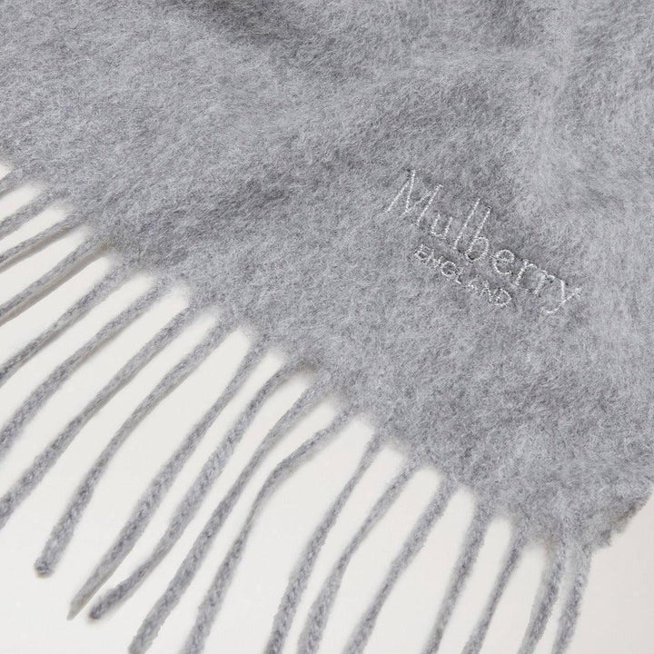 Mulberry Cashmere 30x195 Light Grey Melange toont een lichtgrijze, zachte cashmere sjaal met franjes. ModelVS4460885C914.