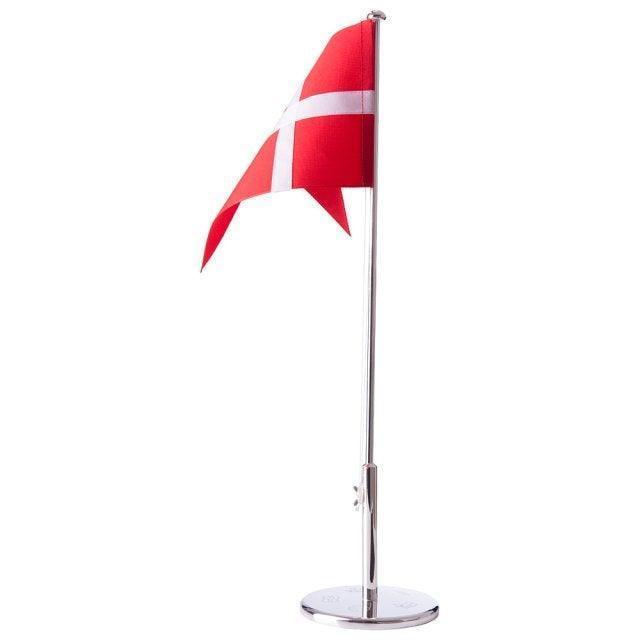 Nordahl Andersen vlaggenmast met motieven toont een zilveren tafelvlaggenmast met een rode Dannebrog-vlag. Model 150-81024-1