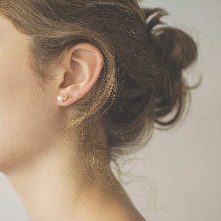 Polar Jewelry Bubble vergulde oorsteker afgebeeld op het oor, elegante parel en gouden detail. ModelWP-00140-2