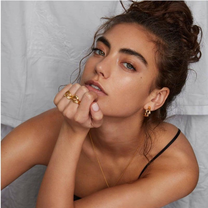 Polar Jewelry Cosmos Gold Plated Hoop Single lijkt gedragen door vrouwen, elegant en goudkleurig. Model COS-HP-GD-WZ-00403