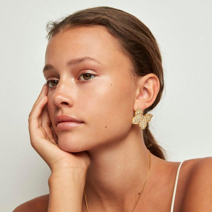 Polar Jewelry The Butterfly vergulde oorbel verschijnt aan het oor, grote goudkleurige vlinder met stenen, Model TBU-ST-GD-WZ-00323