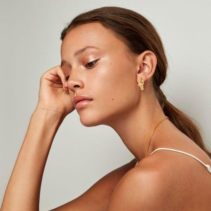 De Prinses op de Erwt oorring gedragen door model, weergegeven in goudkleur, elegant en modern. Model pri-st-gd-wz-00310-2